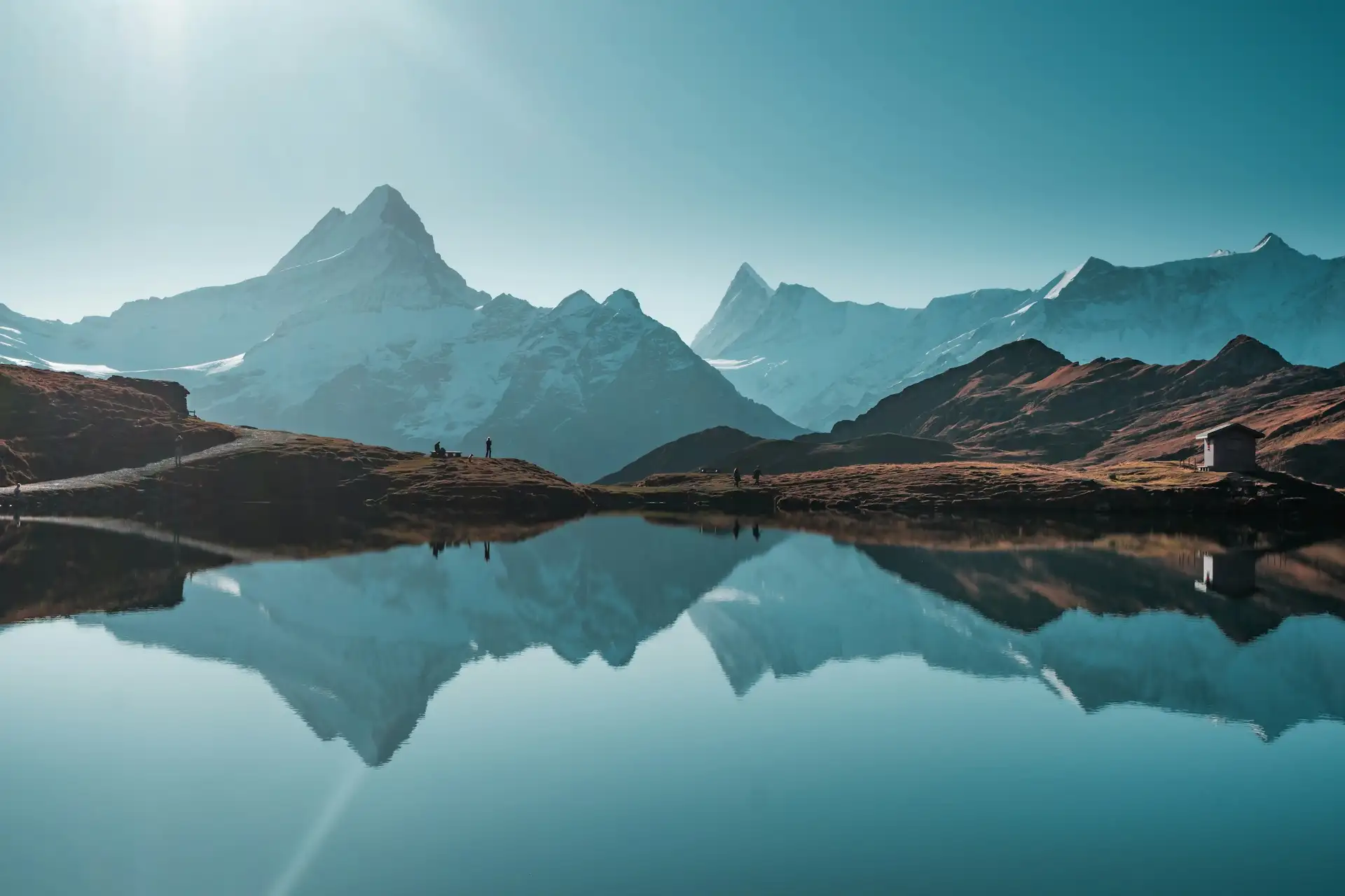 Bergsee mit Spiegelung der schneebedeckten Gipfel