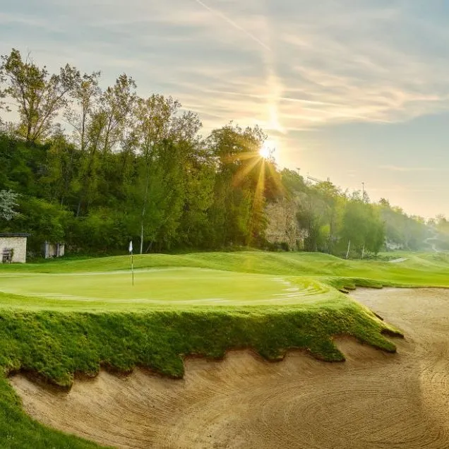 Grün des Mainzer Golfclubs mit Bunker und Felswand im Morgenlicht